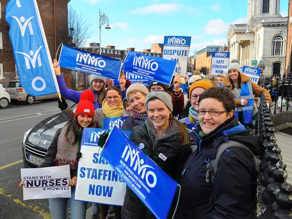 group of nurses at a protest with signs about safe staffing